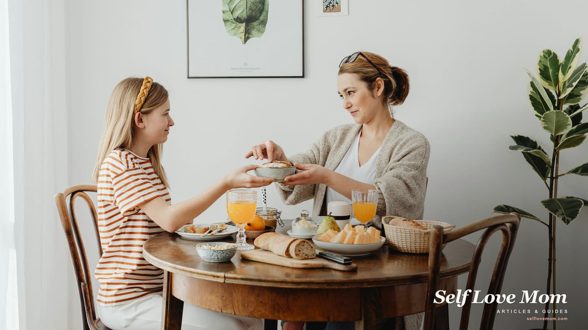 A mother and daughter smiling at each other across a sunlit kitchen table, sharing breakfast.