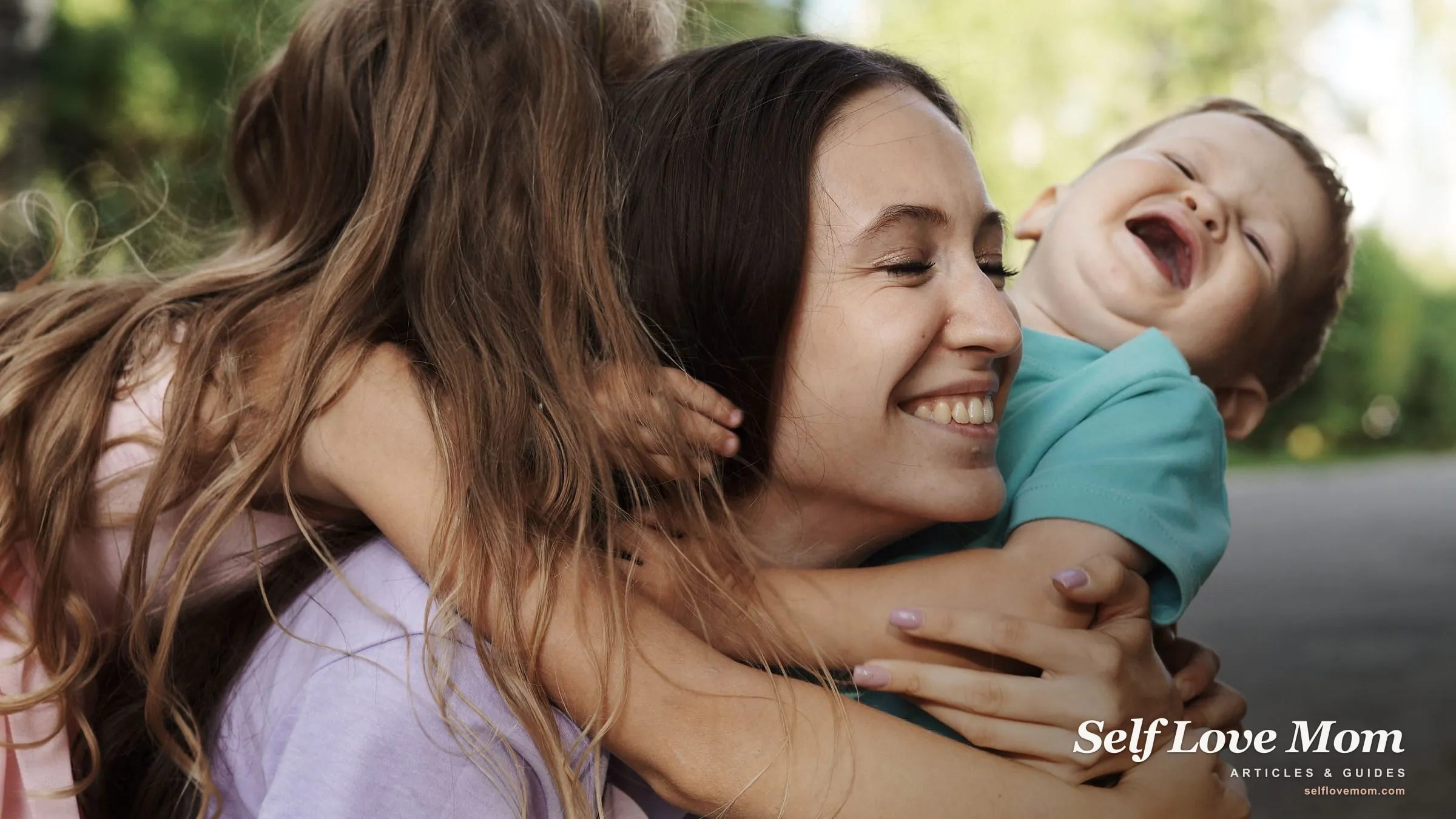 A mother laughs outdoors as her two children hug her close, the warmth at the center of family life.
