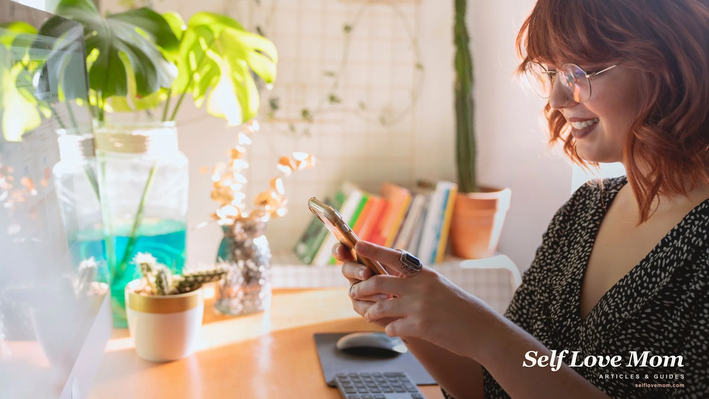 A woman smiles while using a co-parenting app on her phone in a sunny home office, managing a shared schedule.