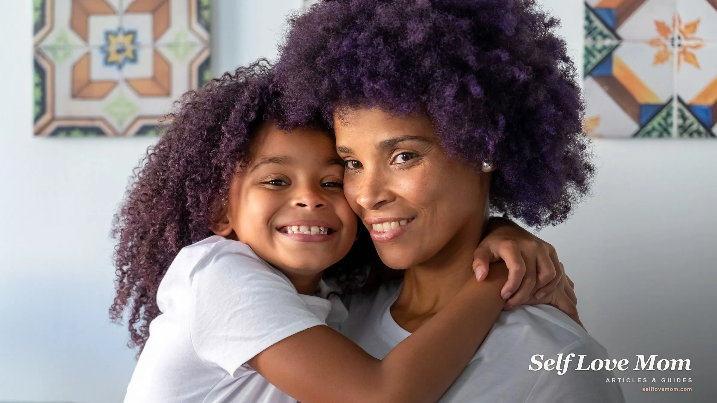 A smiling mother and her young child share a warm cheek-to-cheek hug at home.