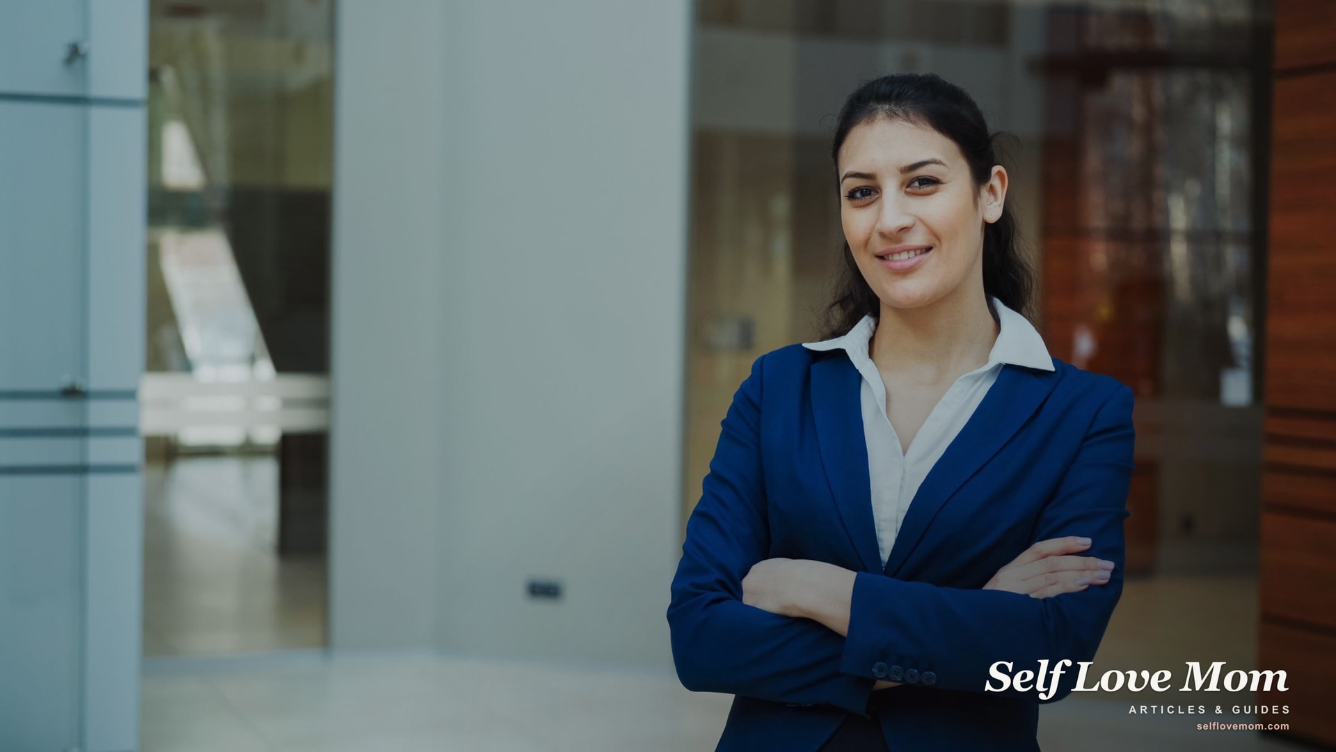 A confident woman smiles in a modern office, representing the stable jobs single moms build, remote and in-person.