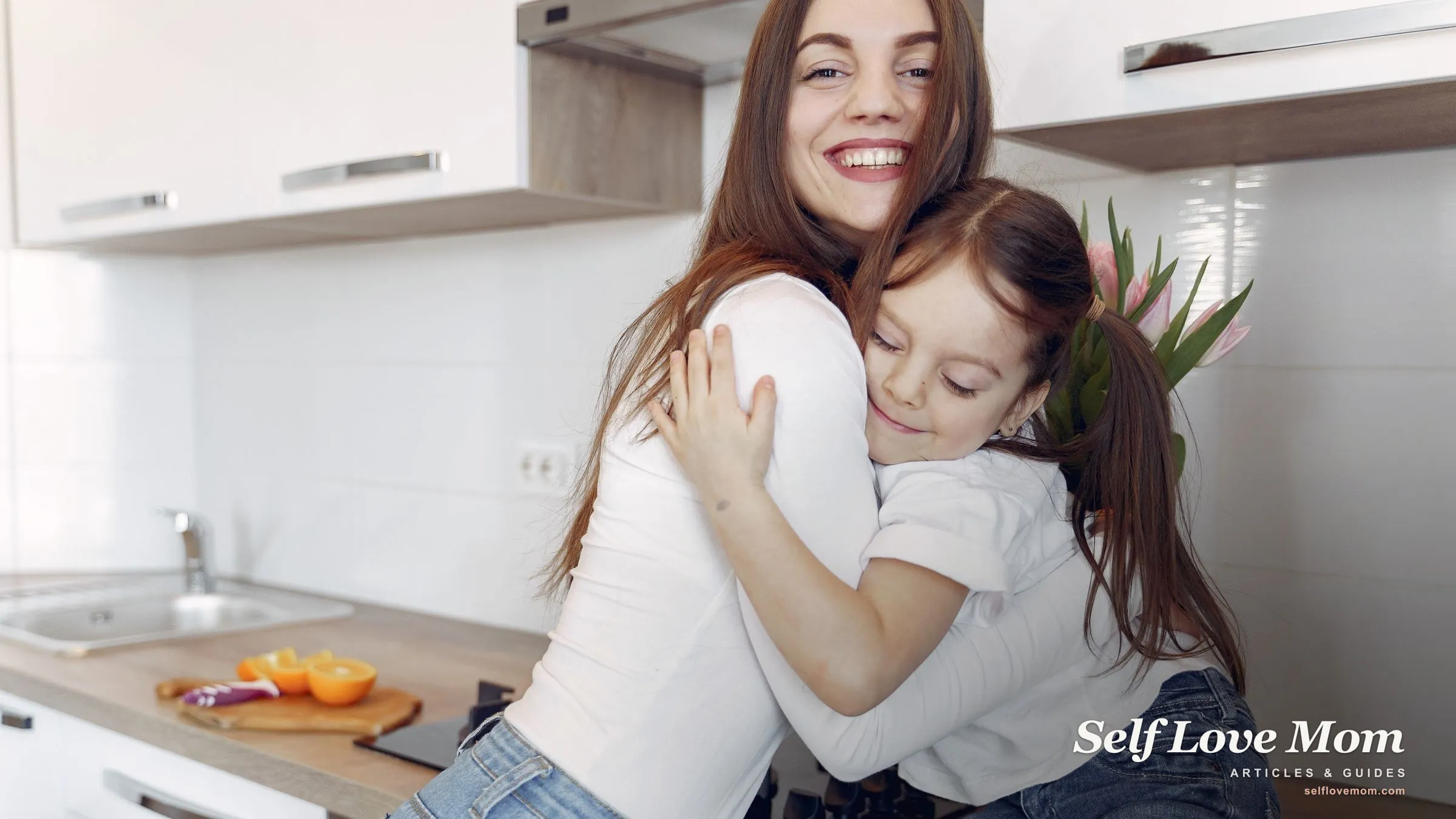 A single mom smiles while hugging her daughter in the kitchen, owning her role with warmth and confidence.