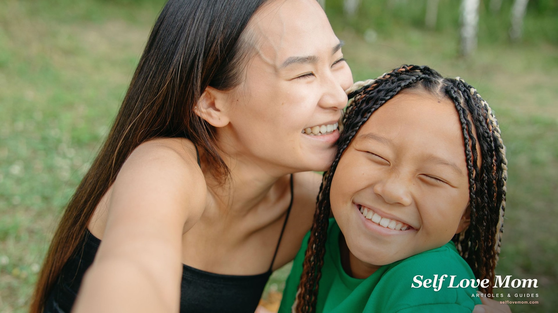 A mother and daughter laugh together outdoors in summer, the season when Summer EBT helps single moms keep kids fed.