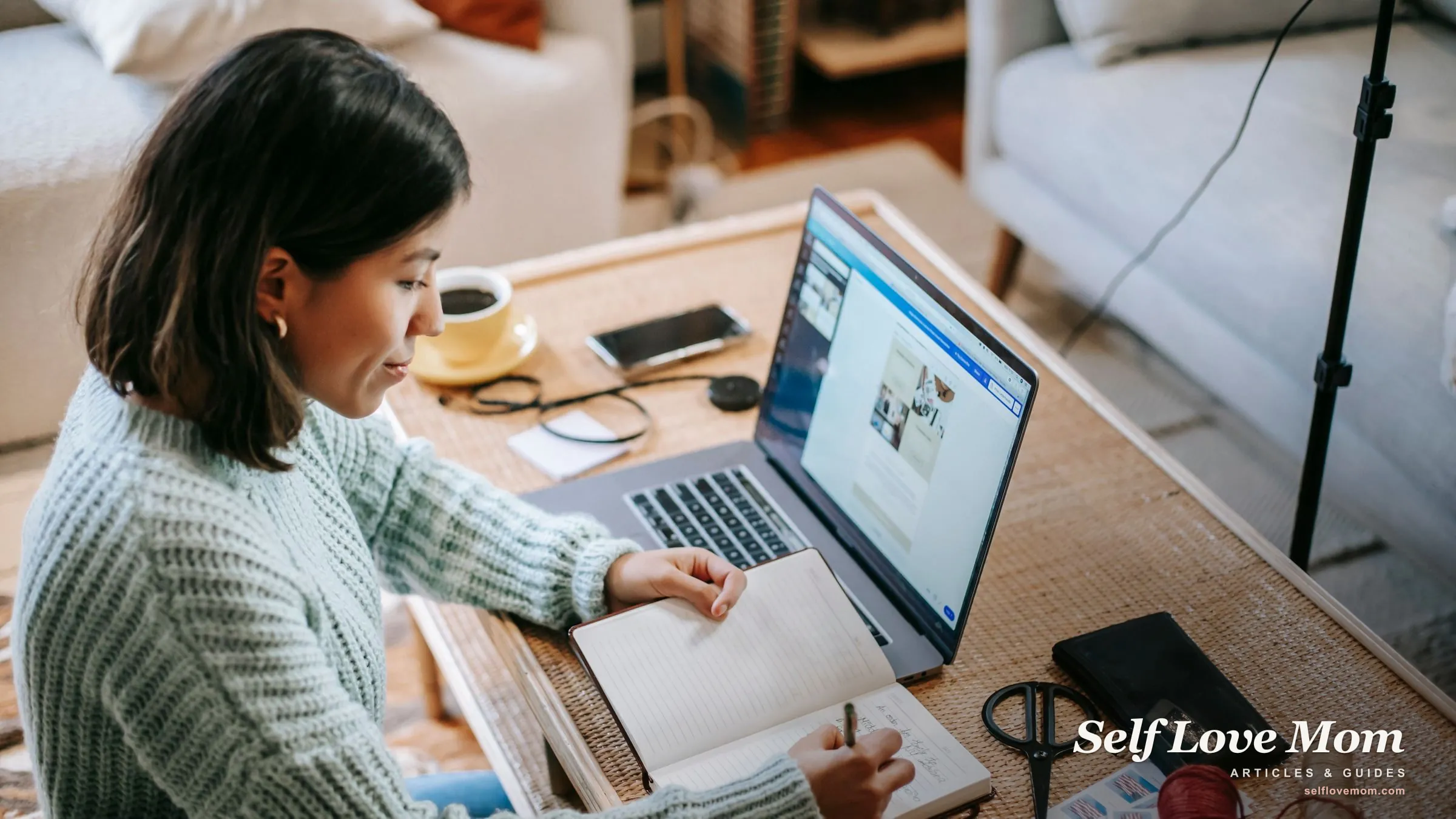 A single mom plans her week at home with a laptop, planner, and phone, her time-management tools in one spot.