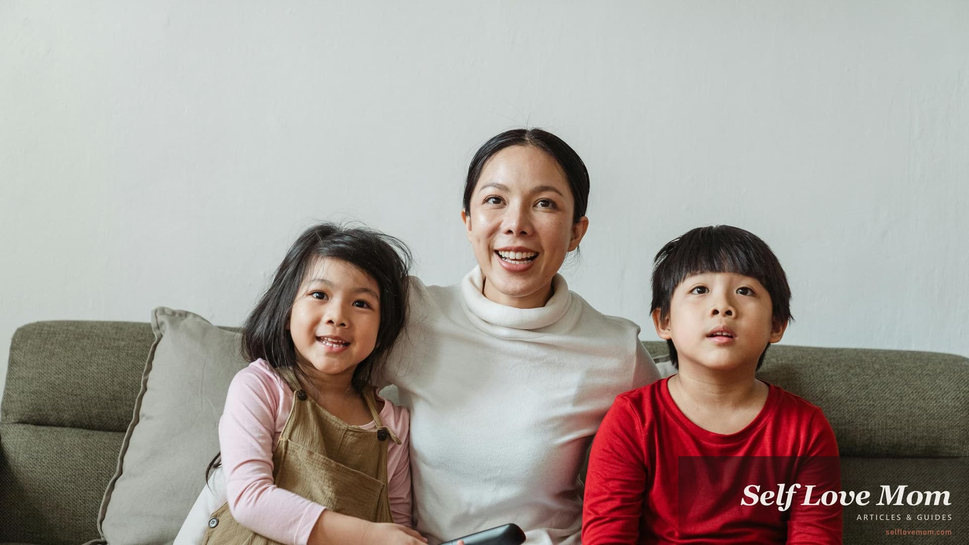 A single mom in Pennsylvania sits on the sofa with her son and daughter, the kind of family moment Pennsylvania's 8+ grant and aid programs in 2026, Cash Assistance, SNAP, PHFA Section 8, CCW, and PA State Grant, are built to support.