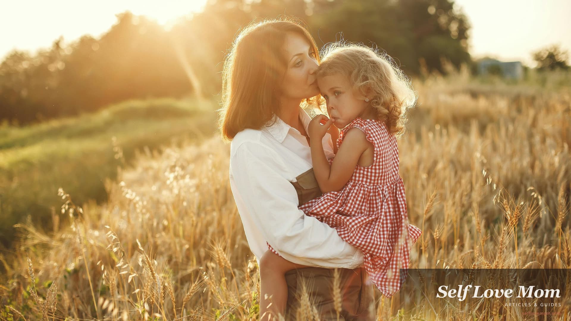 A single mother holds her daughter in a sunlit Texas field, the kind of hopeful family moment grants for single mothers in Texas can help protect.