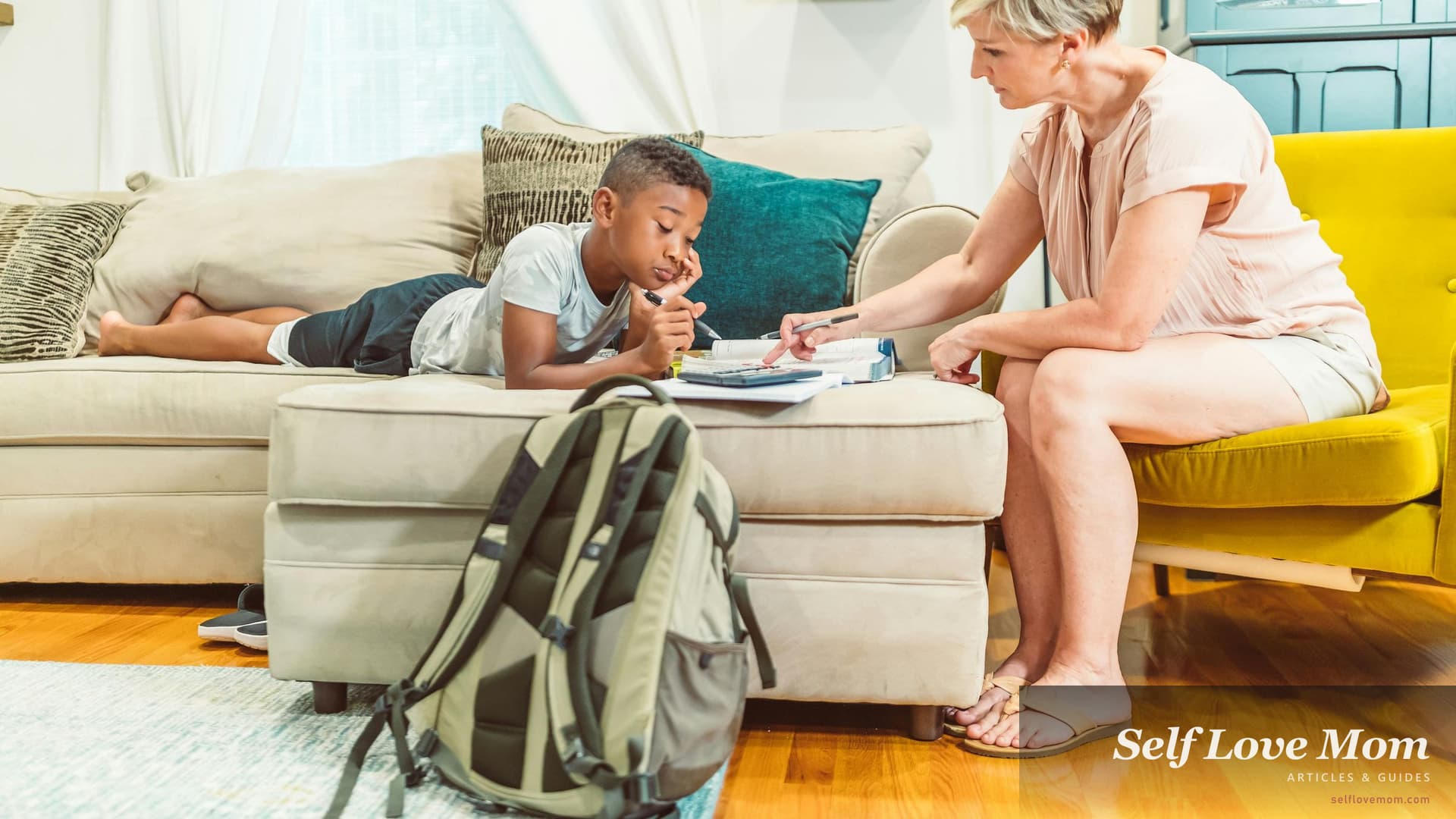 Indiana single mom sits beside her young son on the living-room sofa helping with homework, the kind of steady evening that Indiana TANF cash assistance and the IMPACT job-training program exist to protect while a parent gets back to work.