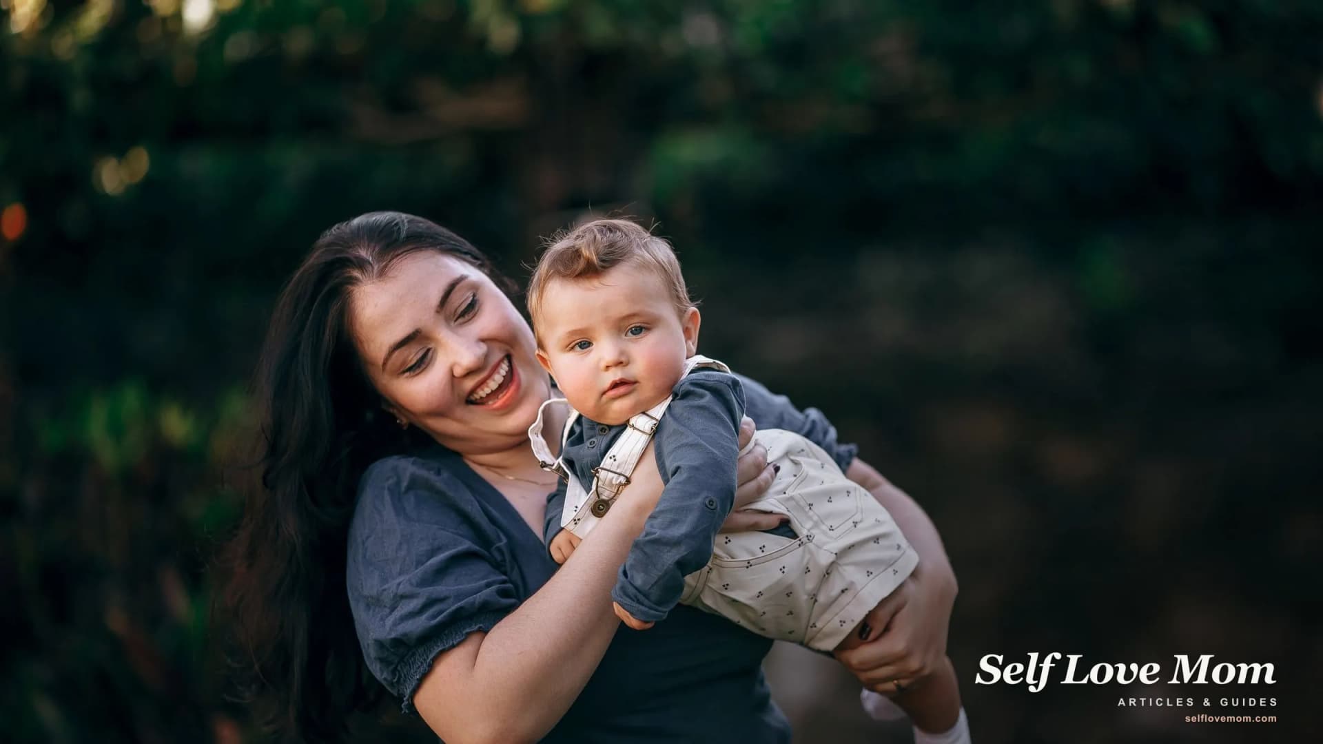 A single mom smiles while holding her baby outdoors, the kind of family free diaper programs are there to support.