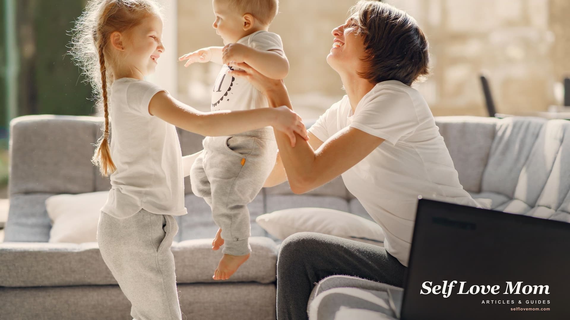 A smiling mother plays with her two children in the living room of their home, the stable housing single mums work to secure.
