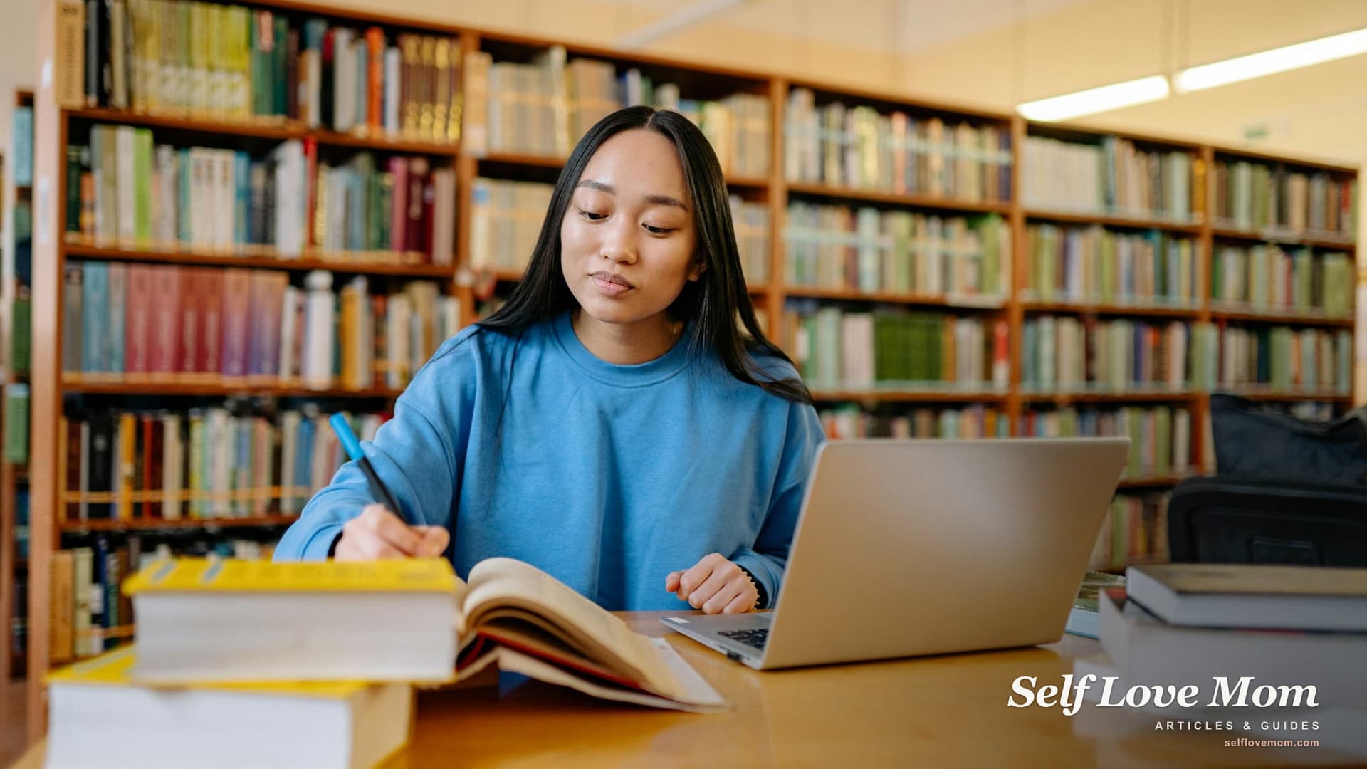 A determined single mom studies with textbooks and a laptop, planning how to pay for her degree