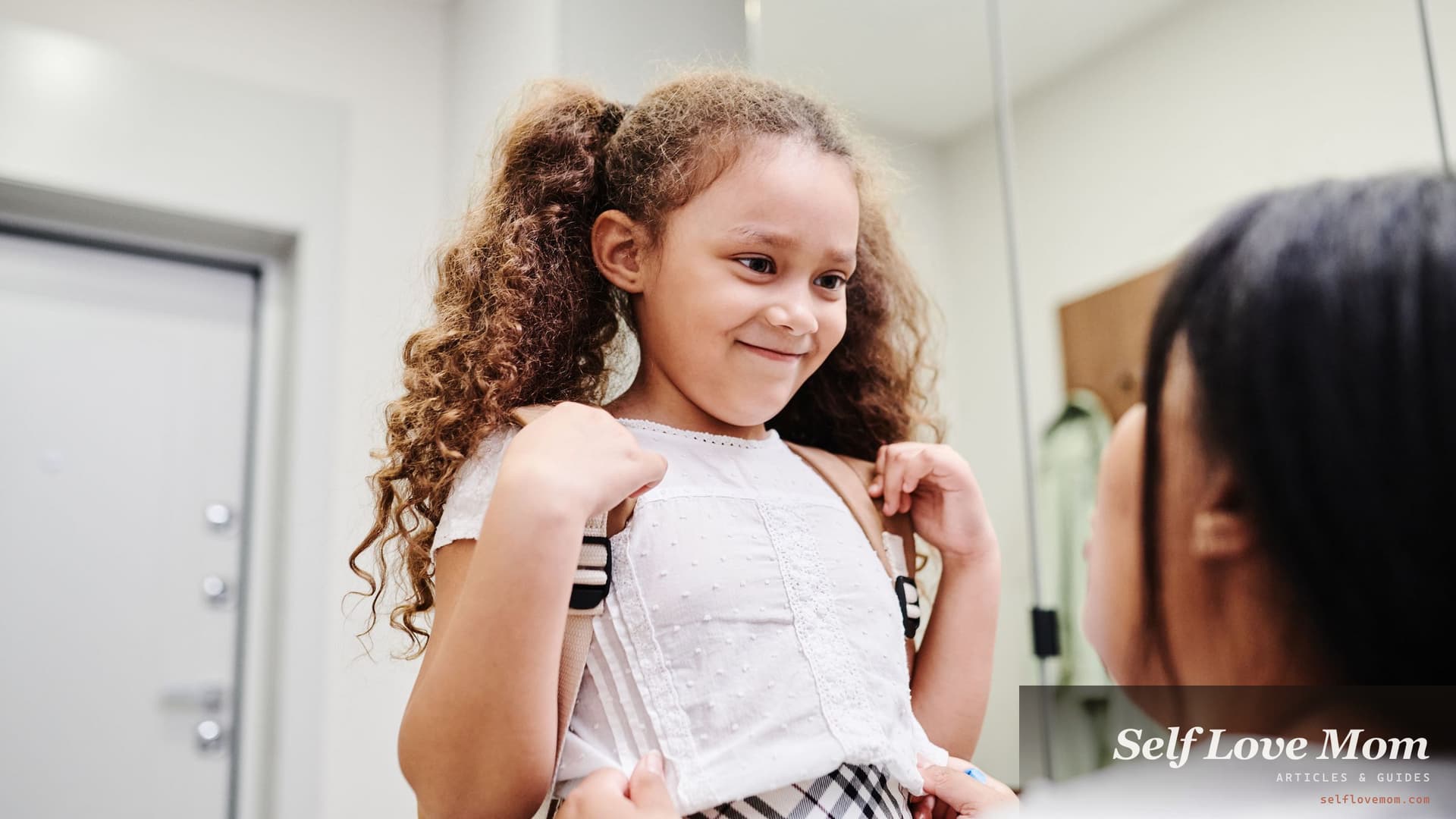 A young daughter wearing her new backpack smiles at her single mom at home after a free school supplies giveaway.