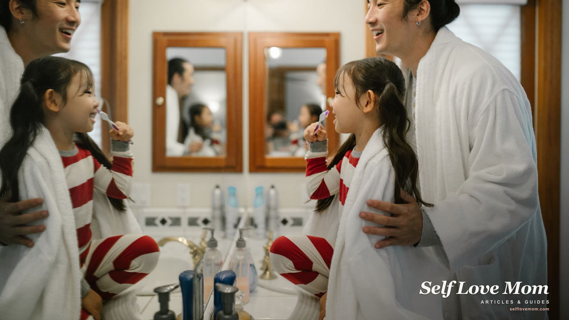 A young child in striped pajamas smiling while brushing their teeth with a parent, part of a calm morning routine for preschoolers.