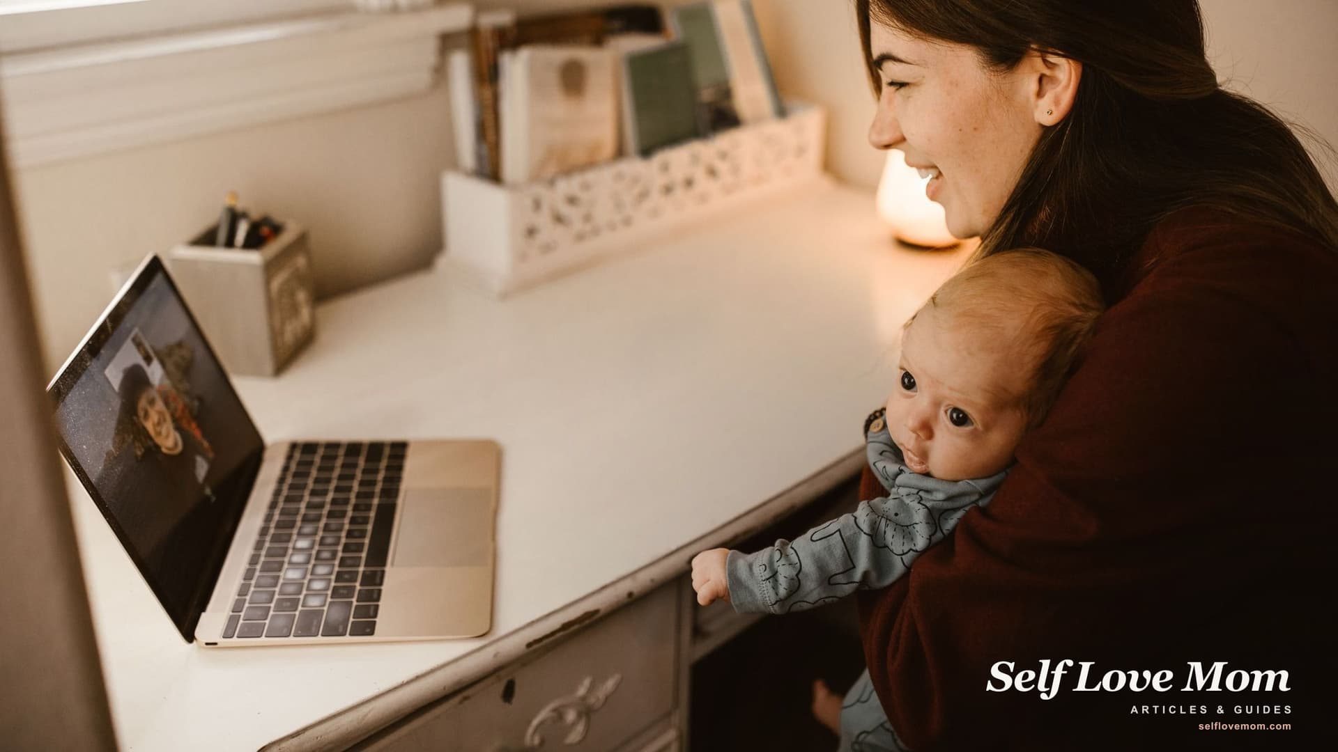 A new mother holds her baby during a video appointment at home, the telehealth route that removes the childcare barrier to therapy.