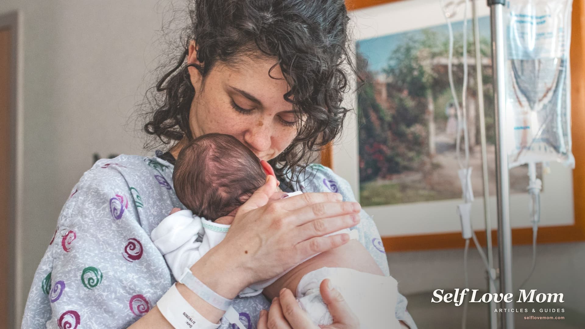 A new mother cradles and kisses her newborn in the hospital, the early postpartum days when therapy and support matter most.