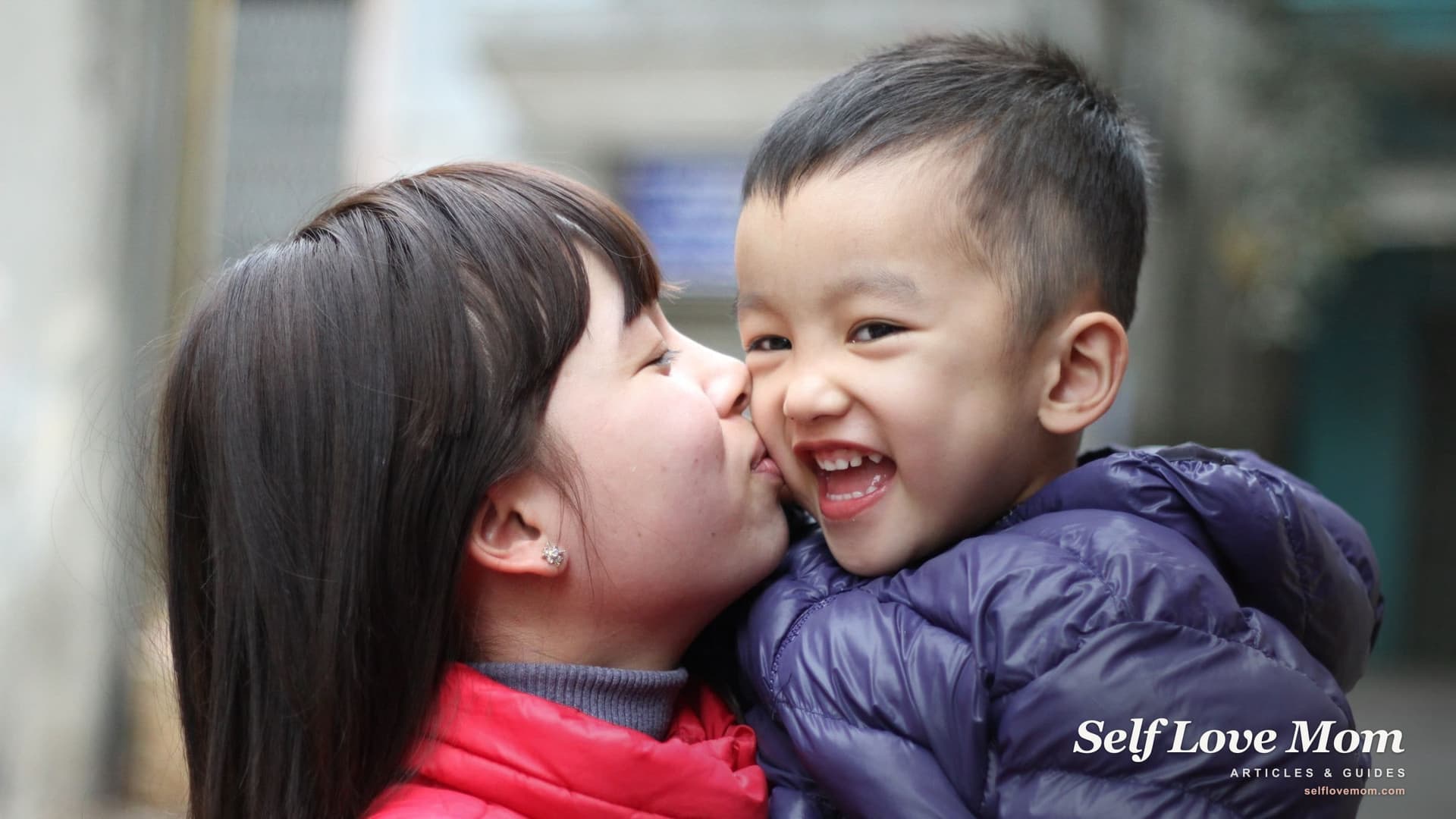 A mother in a winter coat kisses her young son on the cheek outdoors, both wrapped up against the cold, on the kind of Colorado day when heating help and a tax refund matter most