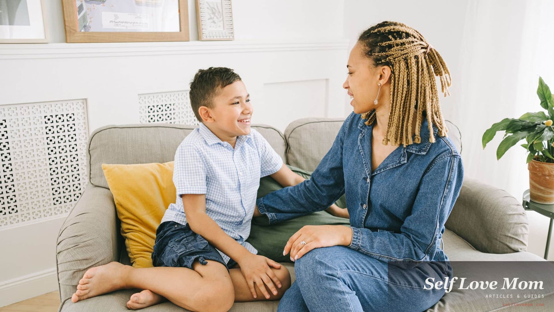 A mother and her young son sit facing each other on the couch, talking before a new partner moves in