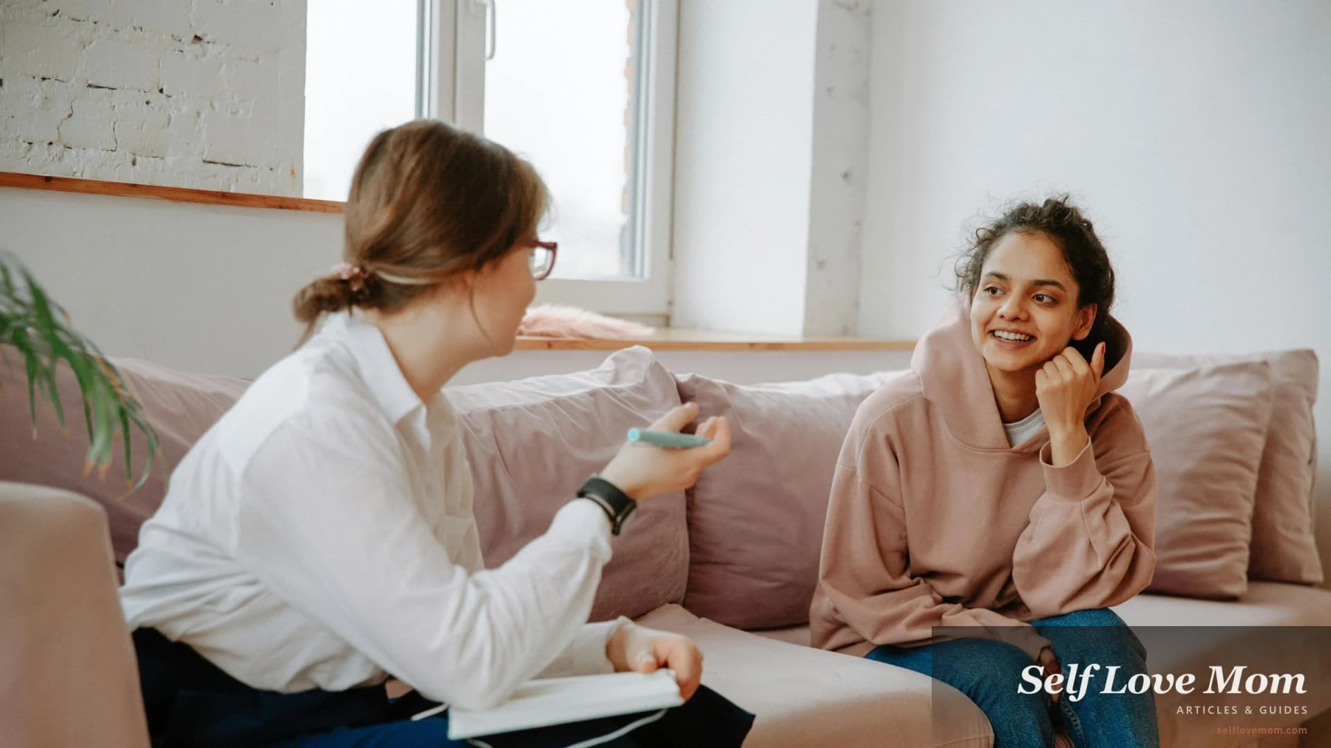 A woman in conversation with her therapist in a calm, light-filled session room. Therapy for single mothers in 2026.
