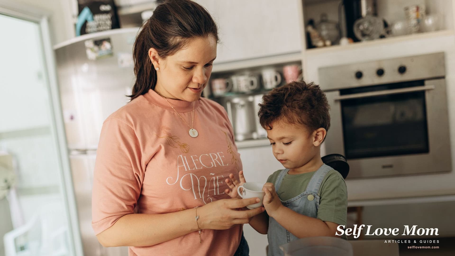 A mother in a peach T-shirt helps her young son with a snack at the kitchen counter, an ordinary weekday moment Minnesota's family programs are built to support.