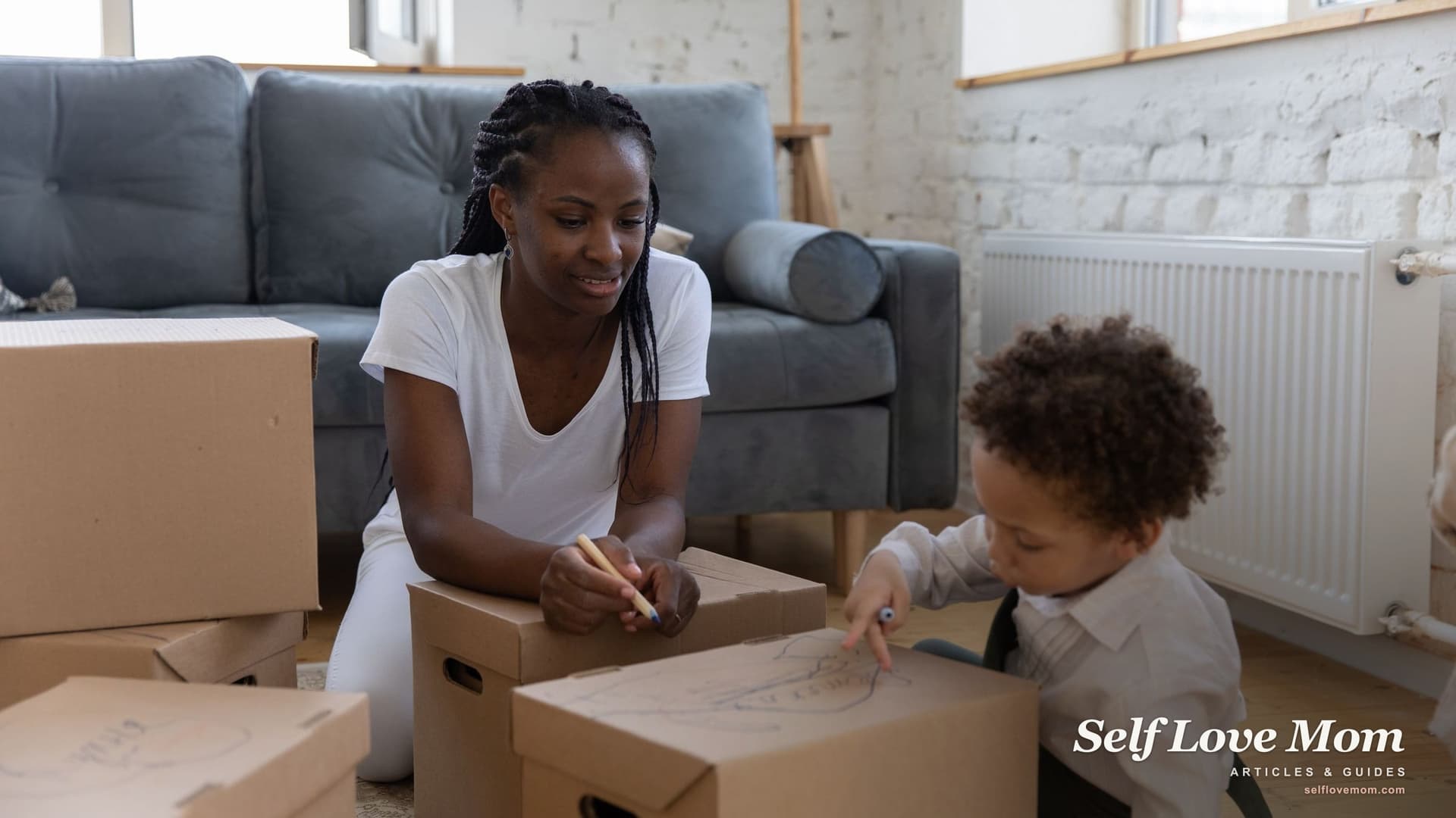 A single mother and her young son unpack moving boxes in a new apartment, the kind of fresh start that housing assistance for single mothers in Pennsylvania can help pay for.