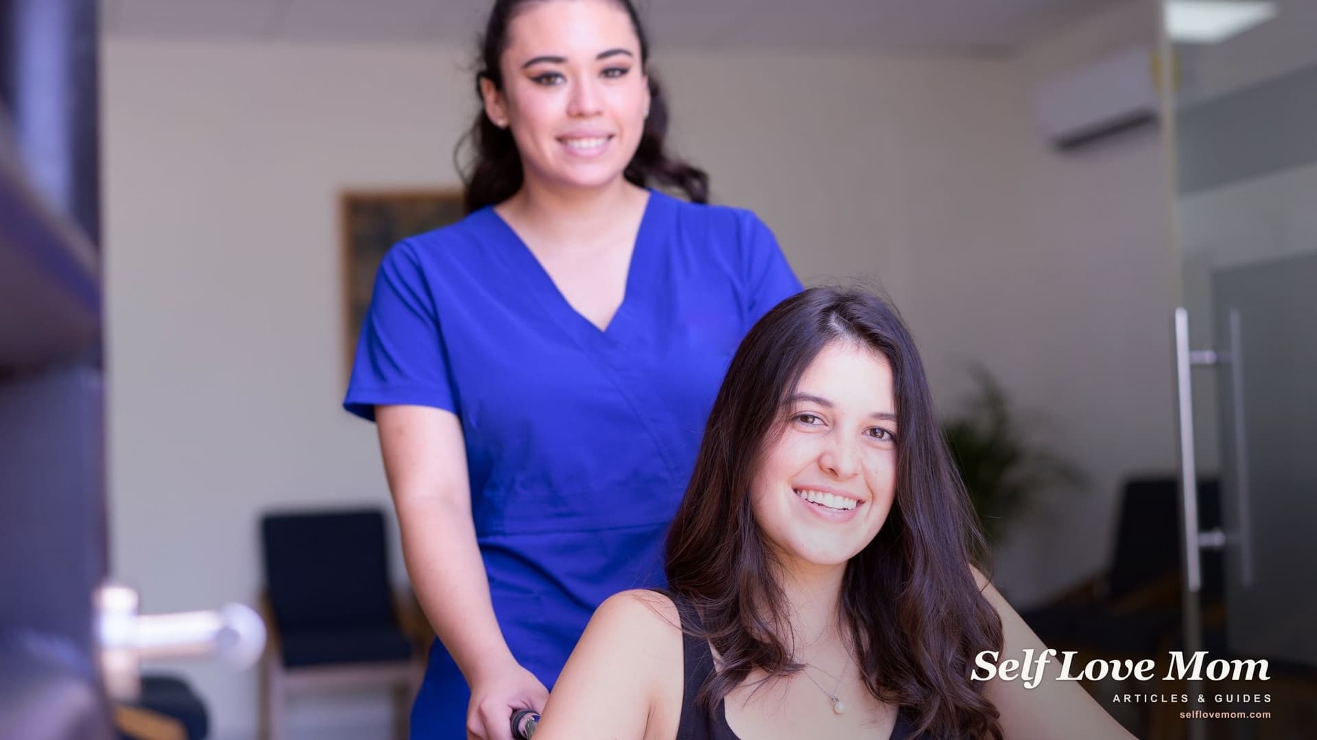 A smiling medical assistant in blue scrubs helps a patient in a wheelchair at a bright clinic, the kind of job a short credential can open.