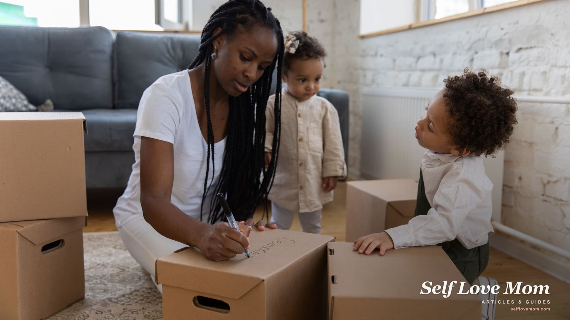 A mother labels moving boxes with her son and toddler daughter in their living room, the kind of move a Section 8 North Carolina voucher can make possible.