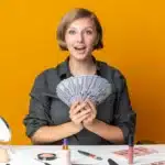 Happy woman holding money representing high paying jobs for single moms working remotely in 2025