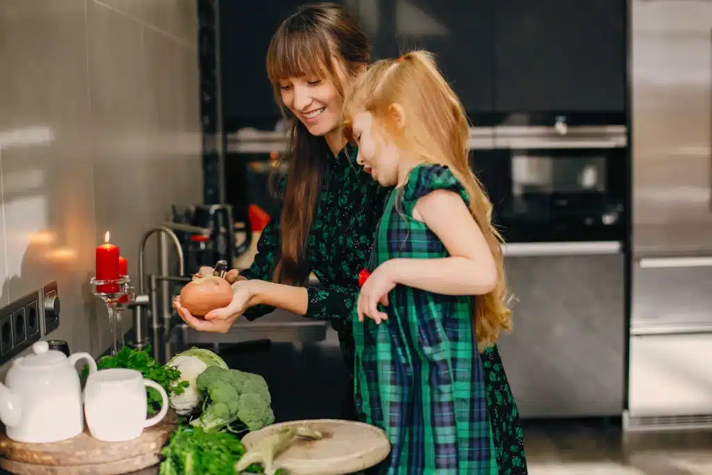 A stay-at-home mom and her daughter enjoying cooking together, a fun and educational learning hobby for stay-at-home moms to bond and develop new skills.