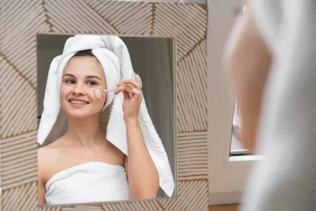 Single mom practicing self-care at home with a face roller – one of the healthy things to do for yourself daily