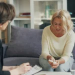 A woman receiving emotional support from a therapist during a counseling for single mothers session.