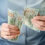 Resources for single moms – woman holding and counting money to represent financial support and assistance.