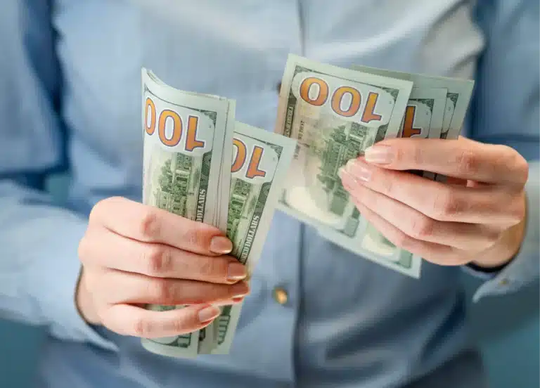 Resources for single moms – woman holding and counting money to represent financial support and assistance.