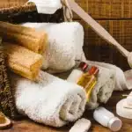 Relaxing self care gift baskets for moms with towels, natural sponges, and skincare products arranged neatly for a spa day at home.